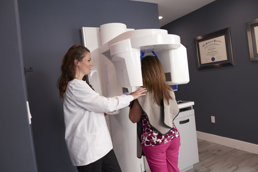 Woman receiving digital panoramic x-rays from the list of general dentistry services at Dental Wellness Team in Coral Springs FL.